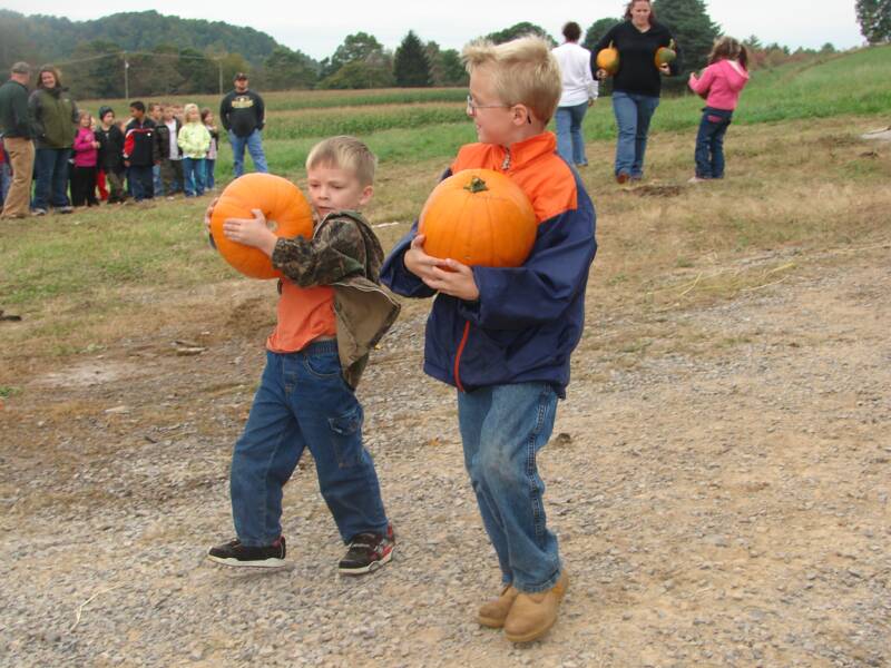 Excited boys carrying their prize pumpkins