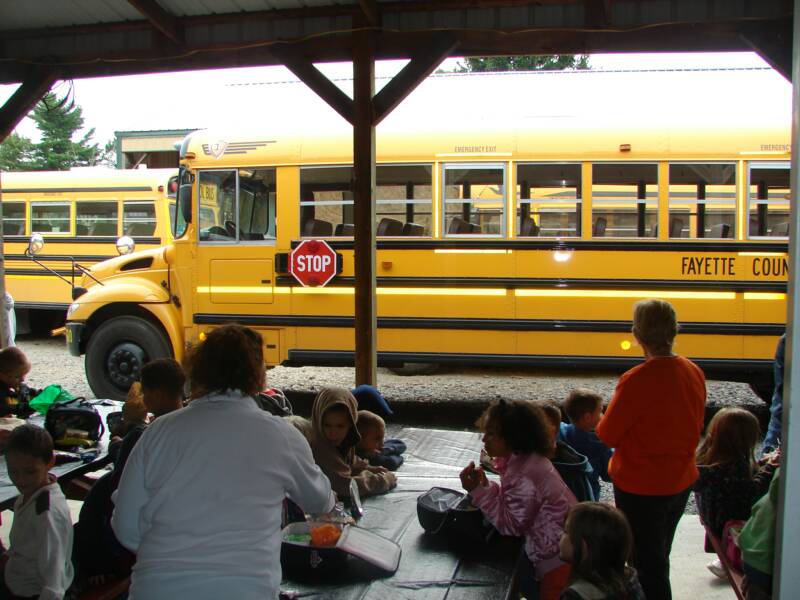 Everybody eating lunch at the picnic tables